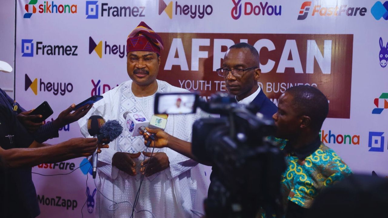 Dr. Michael Thompson sitting while being interviewed by young attendees african youth event.